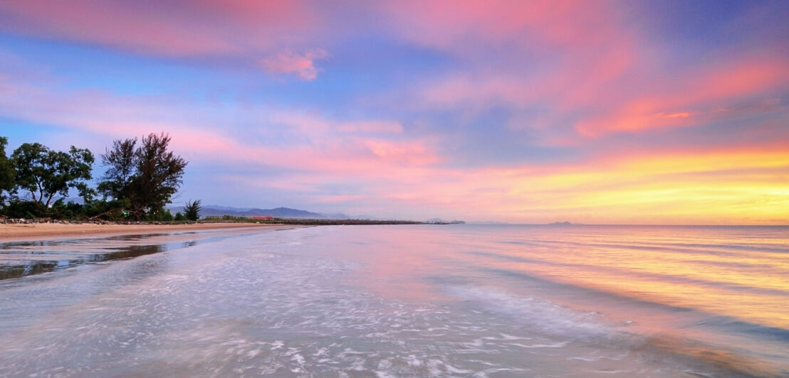 Strandabschnitt und Meer bei Sonnenuntergang.