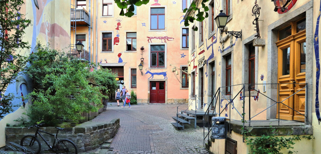 Blick in einen Hinterhof mit kunstvoll gestalteten Hausfassaden. 