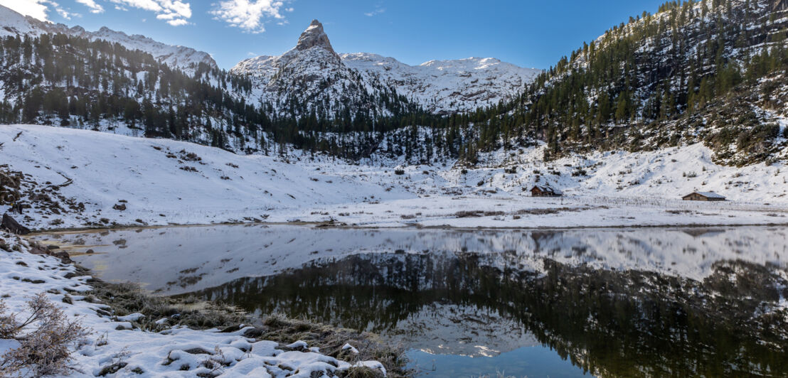 Bergsee mit Gipfelpanorama und Schneelandschaft.