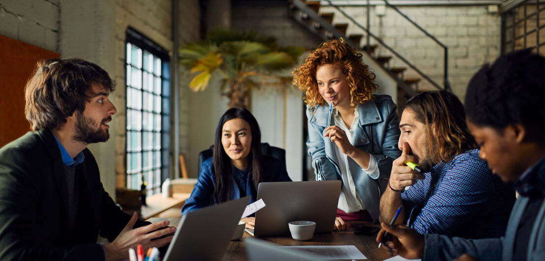 Young and diverse group of designers having a meeting in an office while working in a startup company