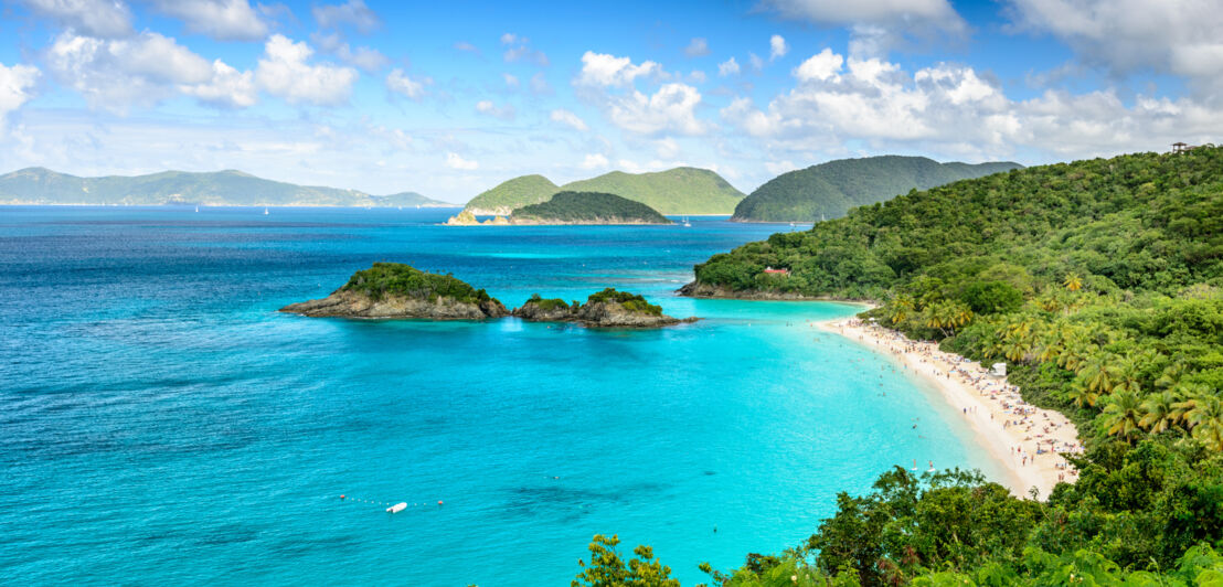 Hügeliges Küstenpanorama mit Dschungel und weißem Sandstrand an türkisblauem Meer.