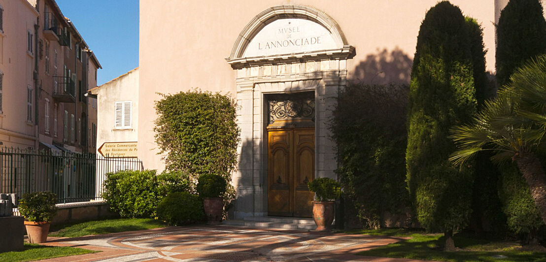 Begrünter Eingangsbereich zu einem Museum in einer Kapelle in einer mediterranen Stadt.