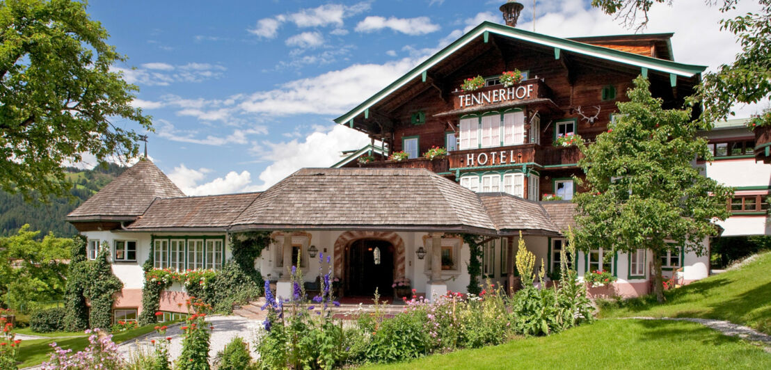 Luxushotel in einem Chalet mit österreichischer Flagge, umgeben von Grünfläche.