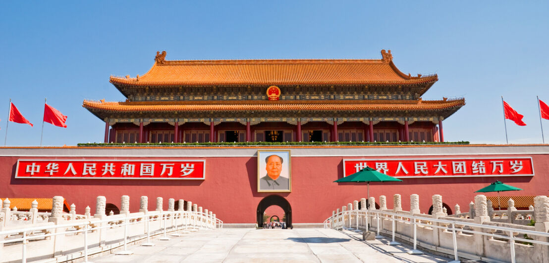 Rotes Eingangstor am Platz des Himmlischen Friedens mit Mao-Porträt und chinesischen Schriftzeichen.