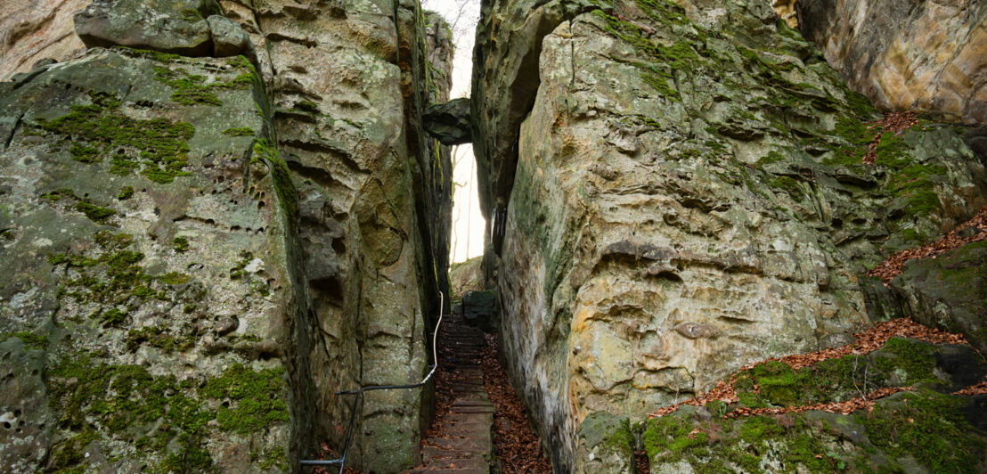 Zwei mächtige Felswände, in deren Mitte eine Spalte ist, in der eine Treppe nach oben führt. Zwei mächtige Felswände, in deren Mitte eine Spalte ist, in der eine Treppe nach oben führt.