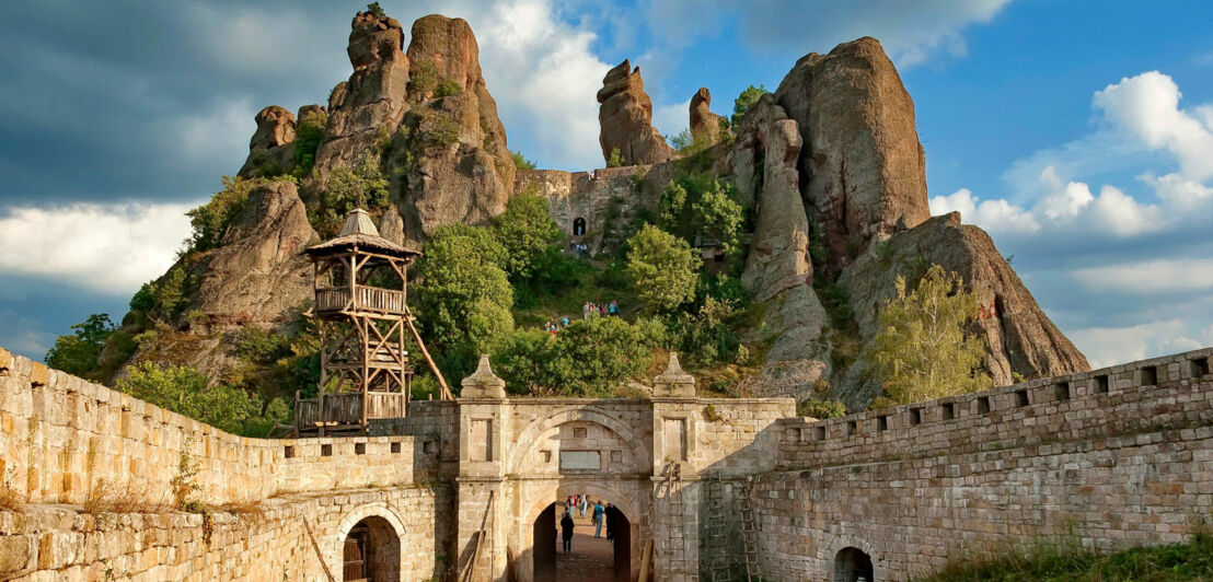 Historische Festung vor Felsformation im Gebirge.