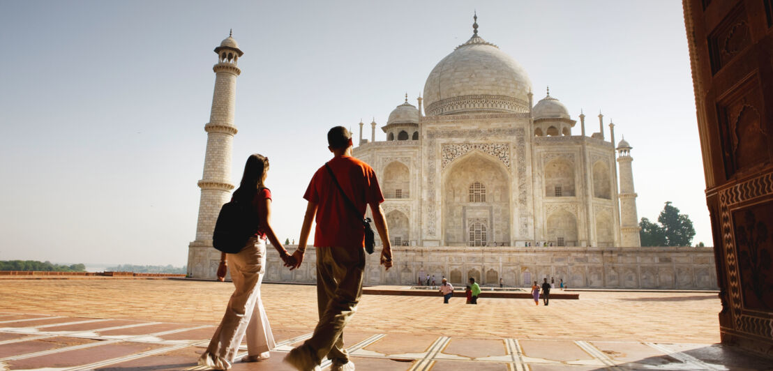 Rückansicht eines handhaltenden Paares auf dem Gelände der Taj Mahal Grabmoschee.