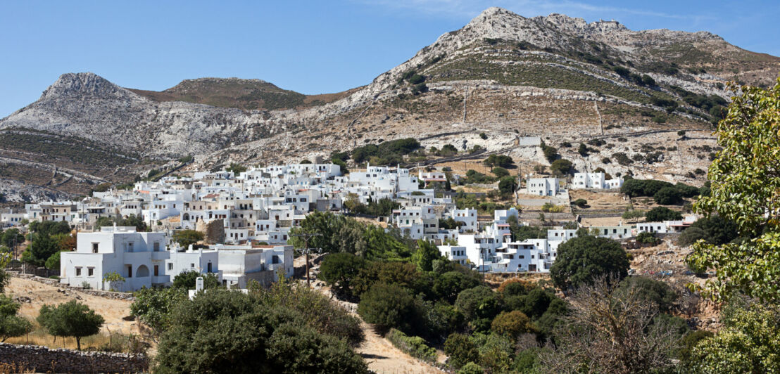 Bergdorf mit weißen Häusern in karger, mediterraner Landschaft.