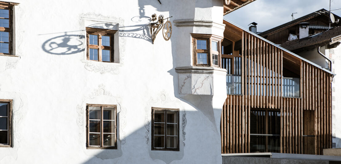 Gebäudekomplex mit weißer, historischer Fassade und moderner Architektur mit Holzdetails. Gebäudekomplex mit weißer, historischer Fassade und moderner Architektur mit Holzdetails.