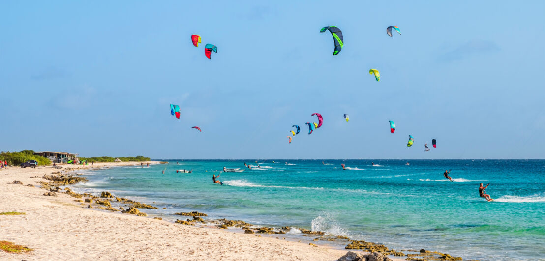 Zahlreiche Kitesurfende im türkisblauen Meer. Zahlreiche Kitesurfende im türkisblauen Meer.