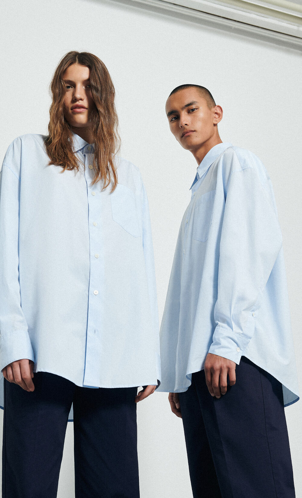 Zwei Models tragen blaue Hemden mit Oversized-Schnitt