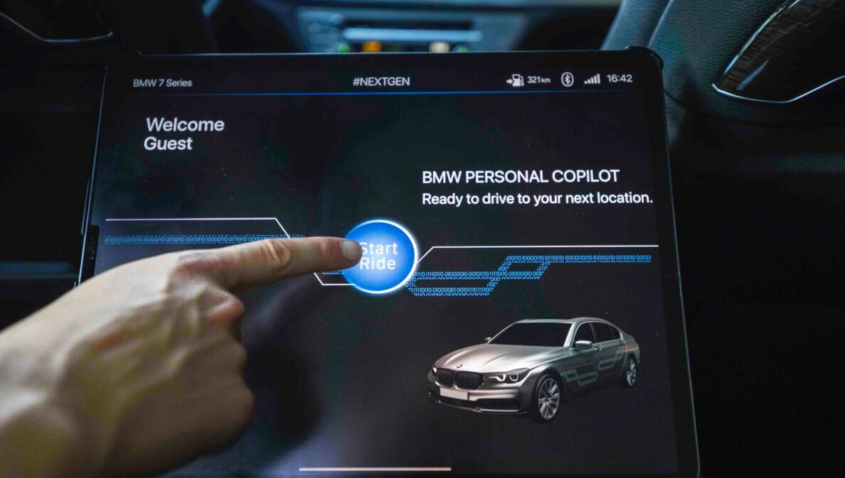 Auf einem Touchscreen im Auto wird die autonome Fahrfunktion durch Antippen mit dem Finger aktiviert