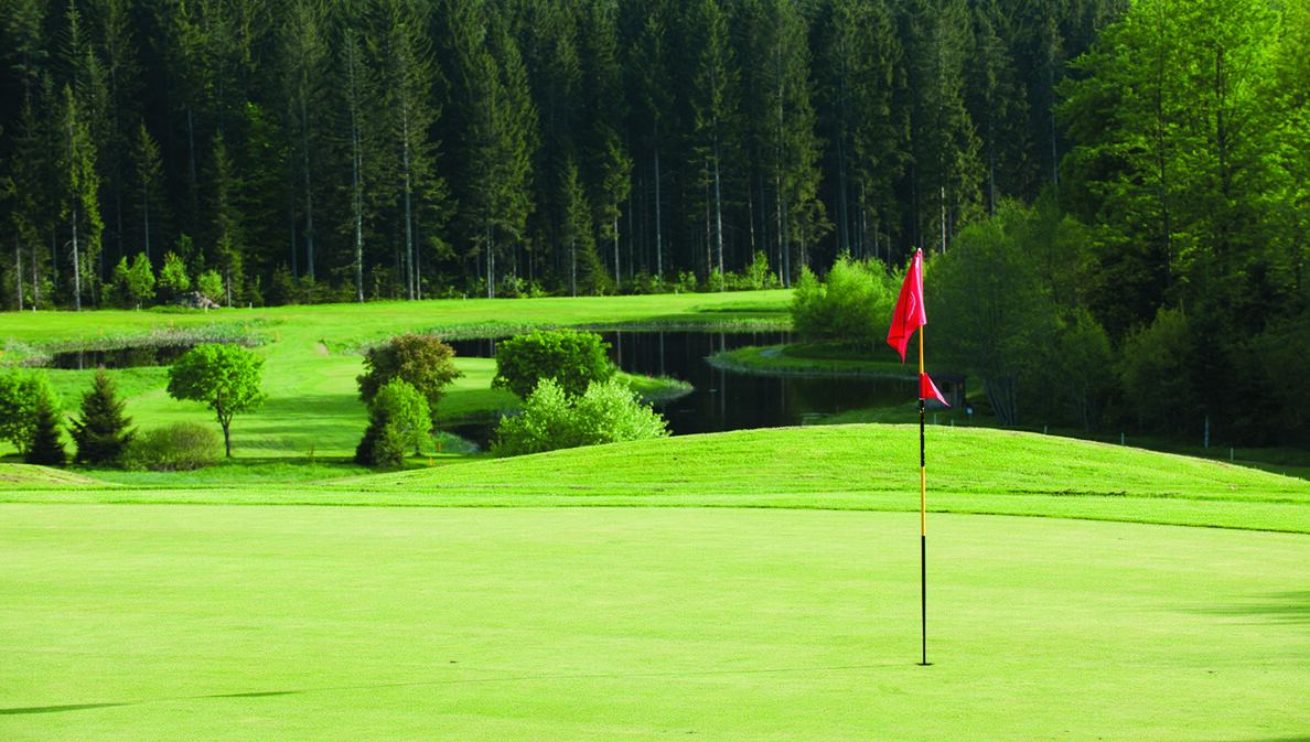 Eine rote Fahne auf dem hügeligen Golfplatz