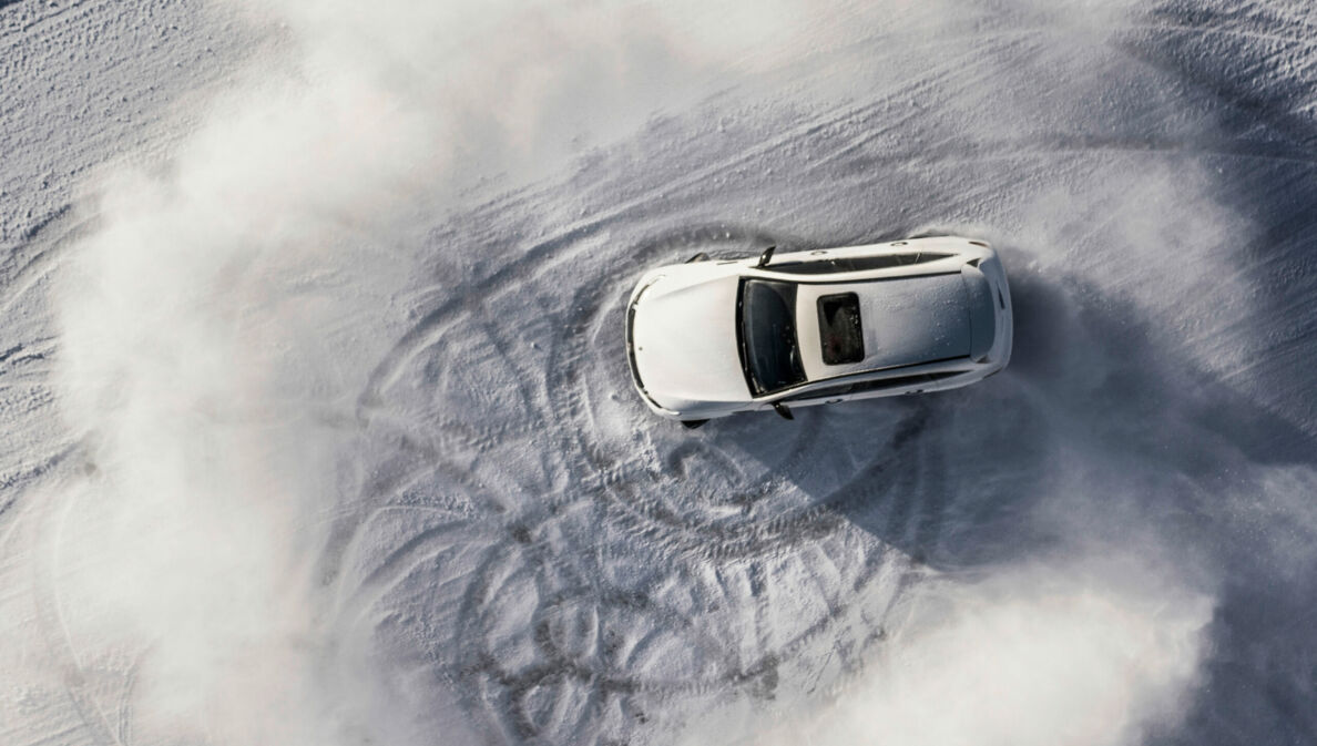 Ein Mercedes E-Auto fährt im Schnee.