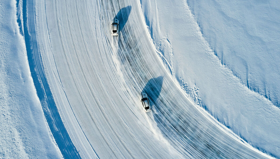 Zwei Sportwagen fahren über ein Eisfeld.