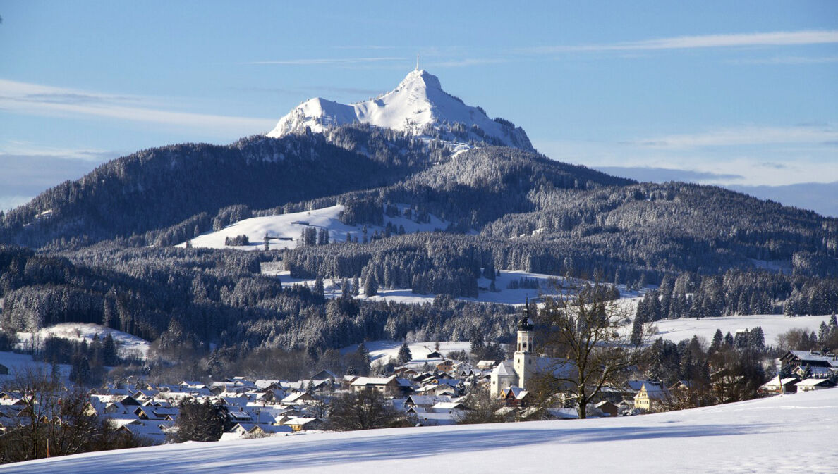 Ein idyllischer, schneebedeckter Ort am Fuße eines Berges mit Skipisten