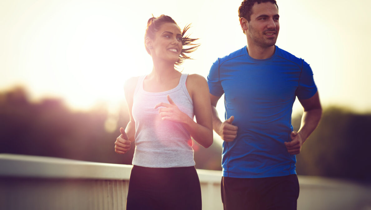 Ein sportliches Paar joggt draußen