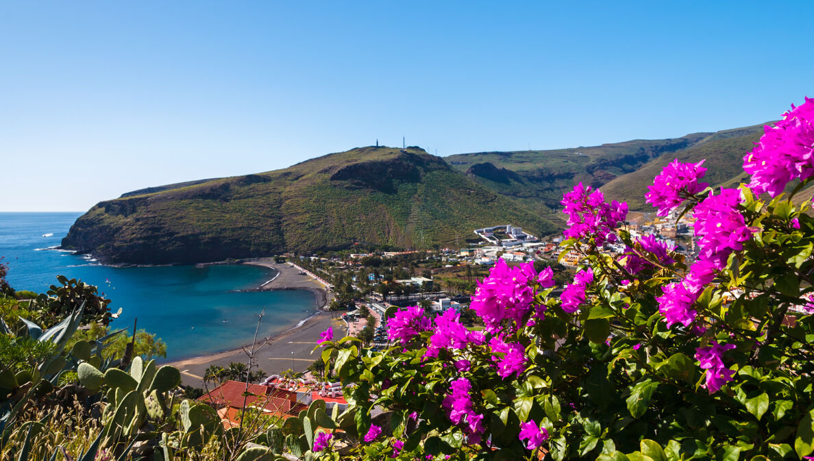 Blick auf die Bucht von Playa de Santiago mit pinken Blumen im Vordergrund