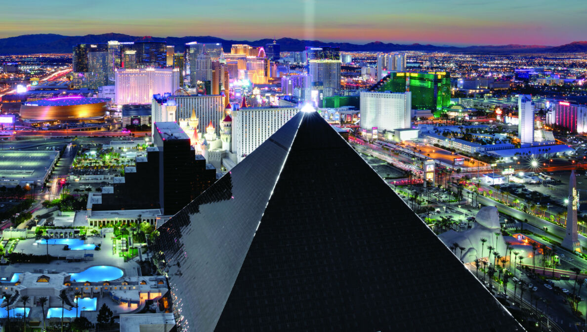 Luftaufnahme von Las Vegas bei Nacht mit einem schwarzen, pyramidenförmigen Gebäude