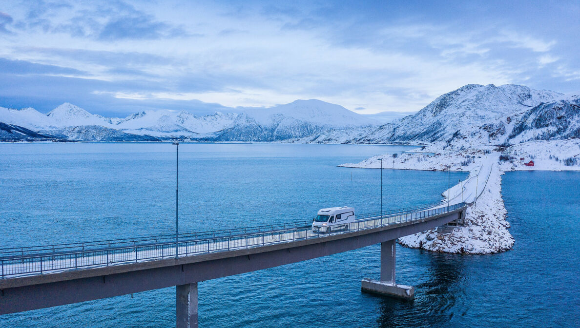 Luftaufnahme einer Brücke an einer Küste mit einem Wohnmobil