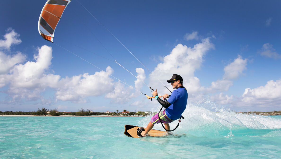 Kitesurfer in türkisfarbenem Wasser