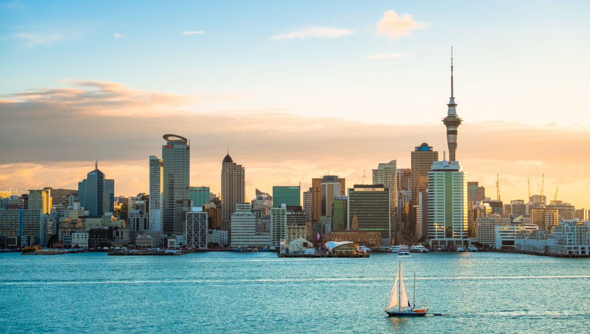 Stadtpanorama von Auckland am Wasser mit einem Segelboot im Vordergrund