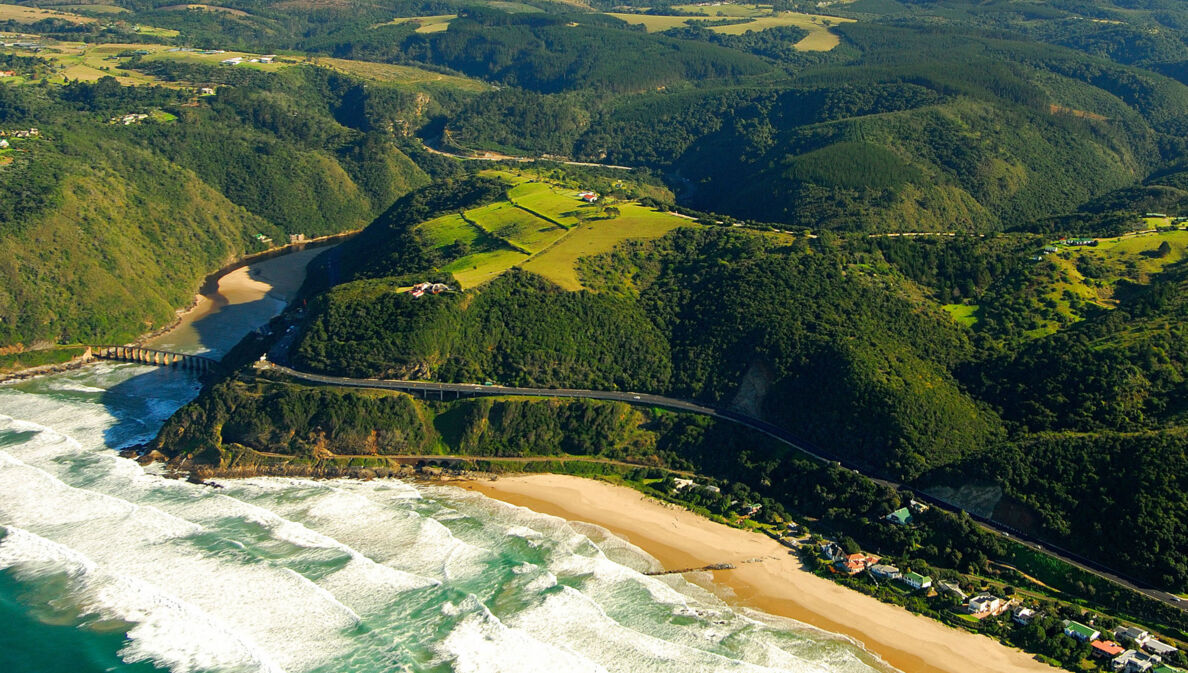 Luftaufnahme der Garden Route, die durch grüne Wälder entlang der Küste führt