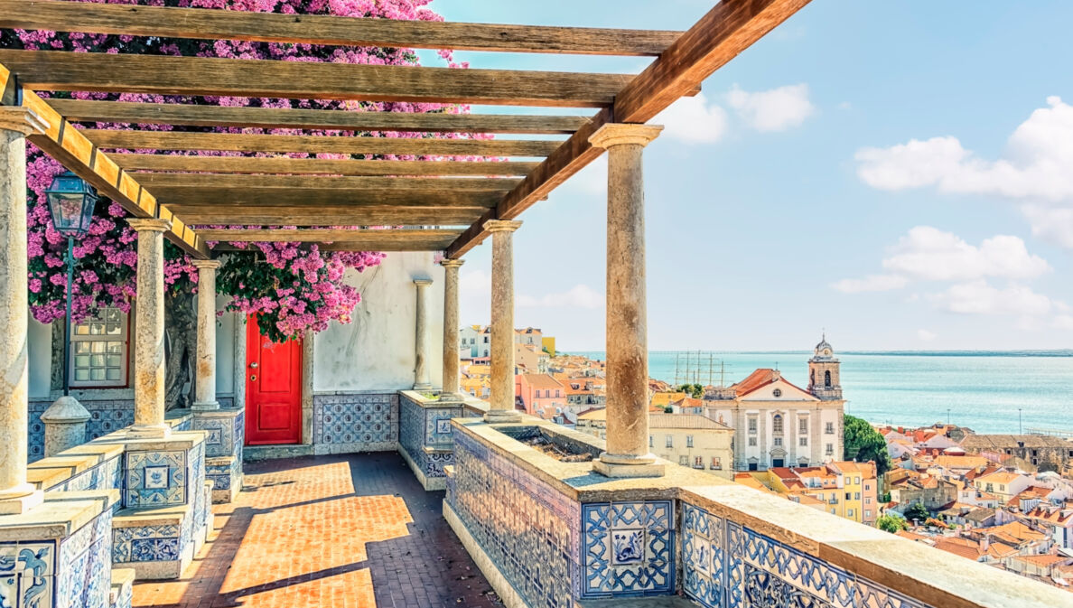 Terrasse mit portugiesischen Kacheln und Bougainvillea mit Blick auf Lissabon am Meer