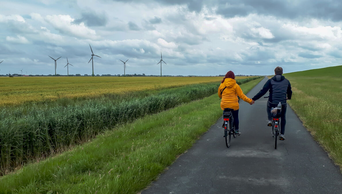 Junges Paar hält Hände beim Radfahren auf dem Elberadweg