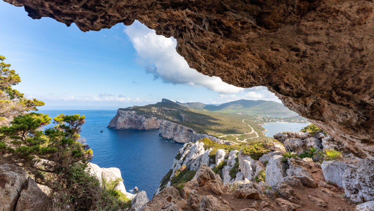 Blick zwischen Felsen hindurch auf eine Landzunge Sardiniens