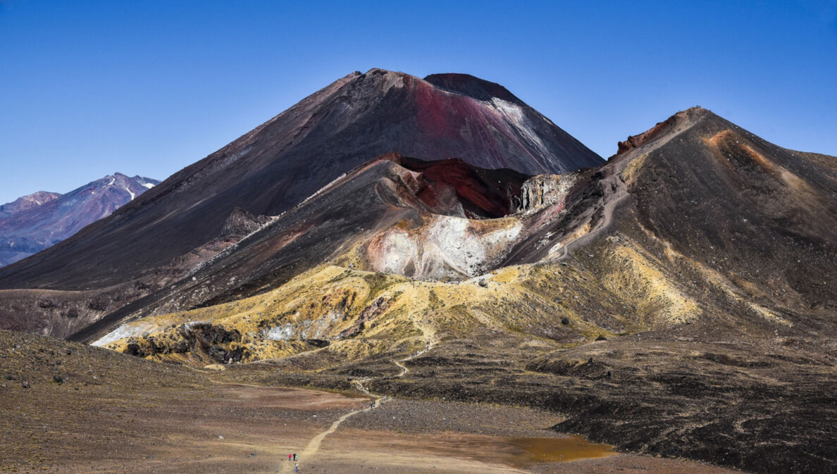 Ein dunkler Vulkan mit roten Farbverläufen in karger Landschaft