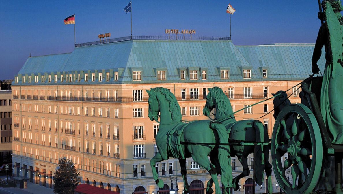 Luftaufnahme der Außenfassade des Hotel Adlon am Pariser Platz mit der Quadriga am Brandenburger Tor im Vordergrund.