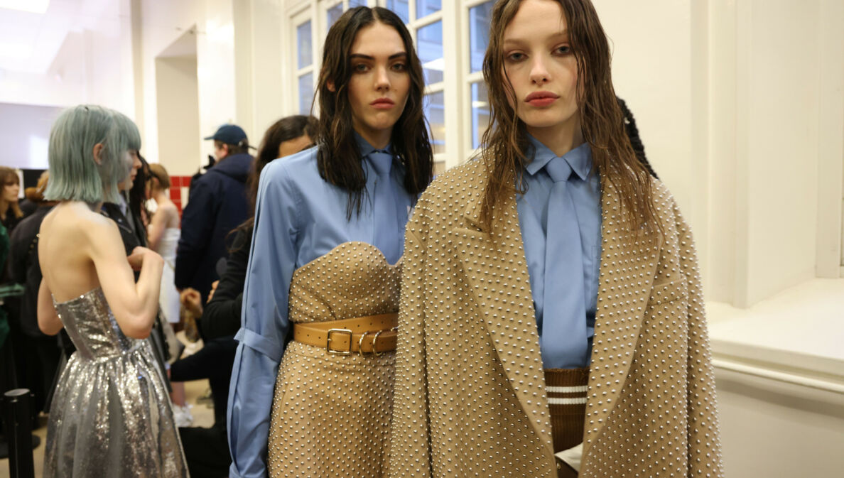 Zwei weibliche Models in eleganter Kleidung in der Farbkombination Beige und Hellblau im Backstage-Bereich einer Modenschau