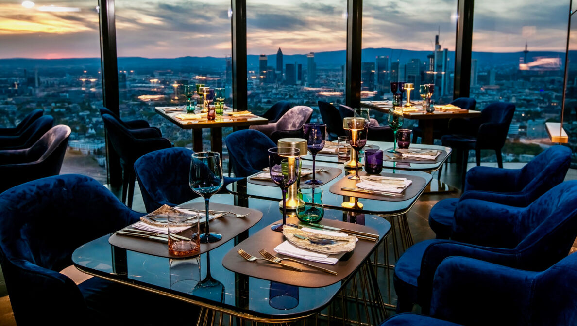 Räumlichkeiten des Restaurant Franziska mit der Skyline Frankfurts im Hintergrund.