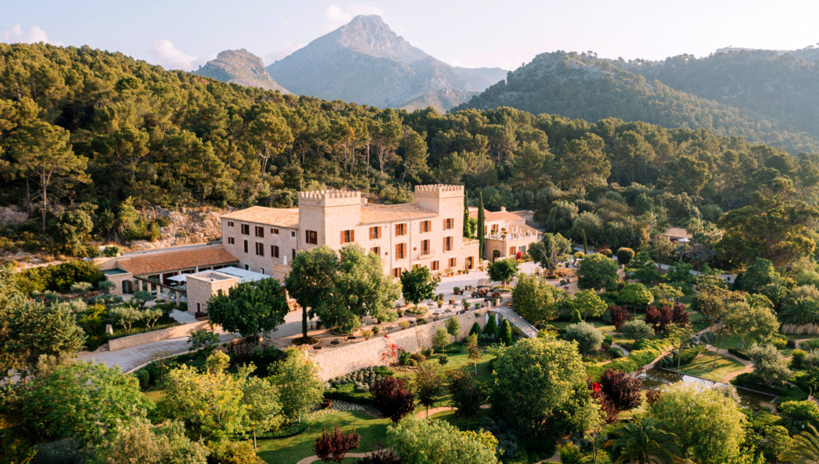 Das historische Hotel Castell Son Claret mit seiner grünen Parkanlage vor der Kulisse des Tramuntana-Gebirges.