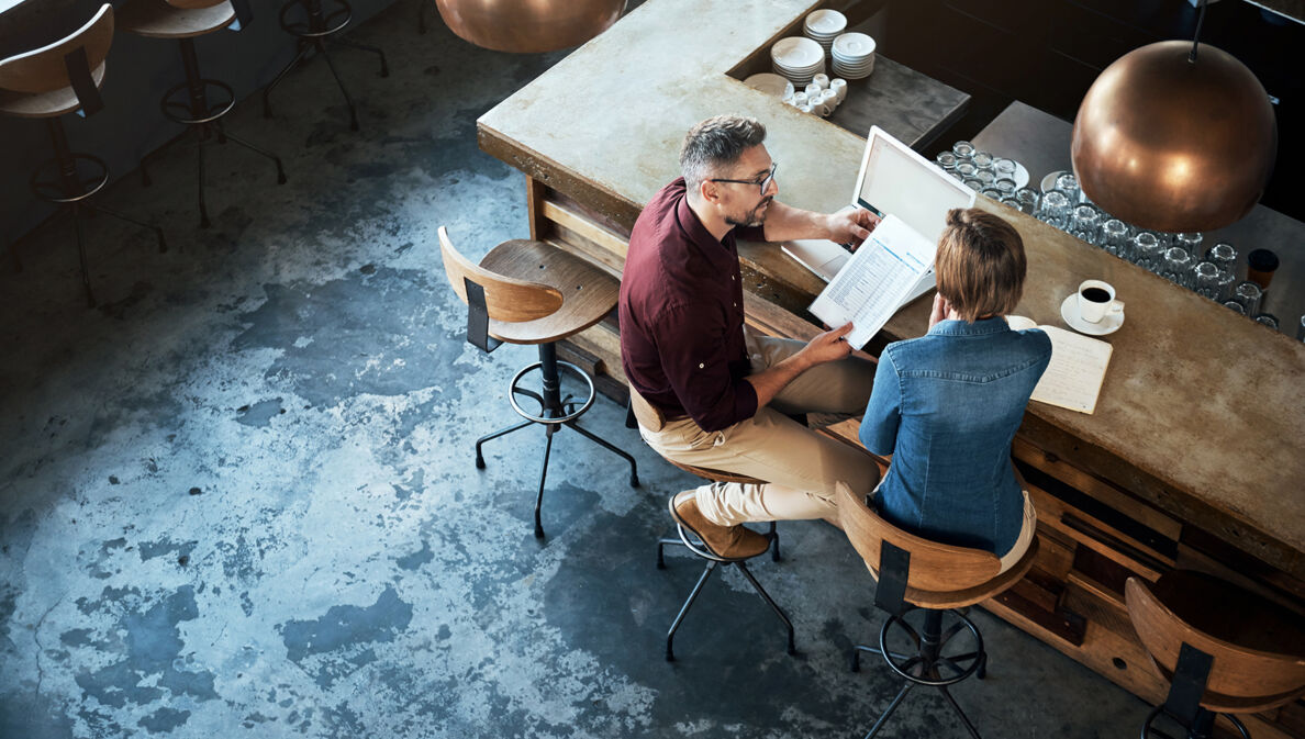 Zwei Geschäftsleute arbeiten am Tresen eines Cafés