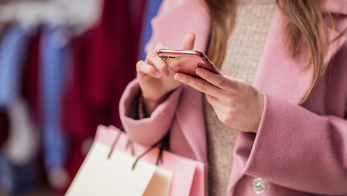 Nahaufnahme einer Frau, die beim Shopping auf ihrem Smartphone tippt