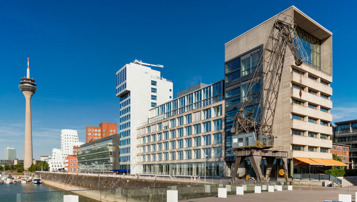 Verschiedene Gebäude mit Kran am Düsseldorfer Binnenhafen, Hintergrund ein Fernsehturm.