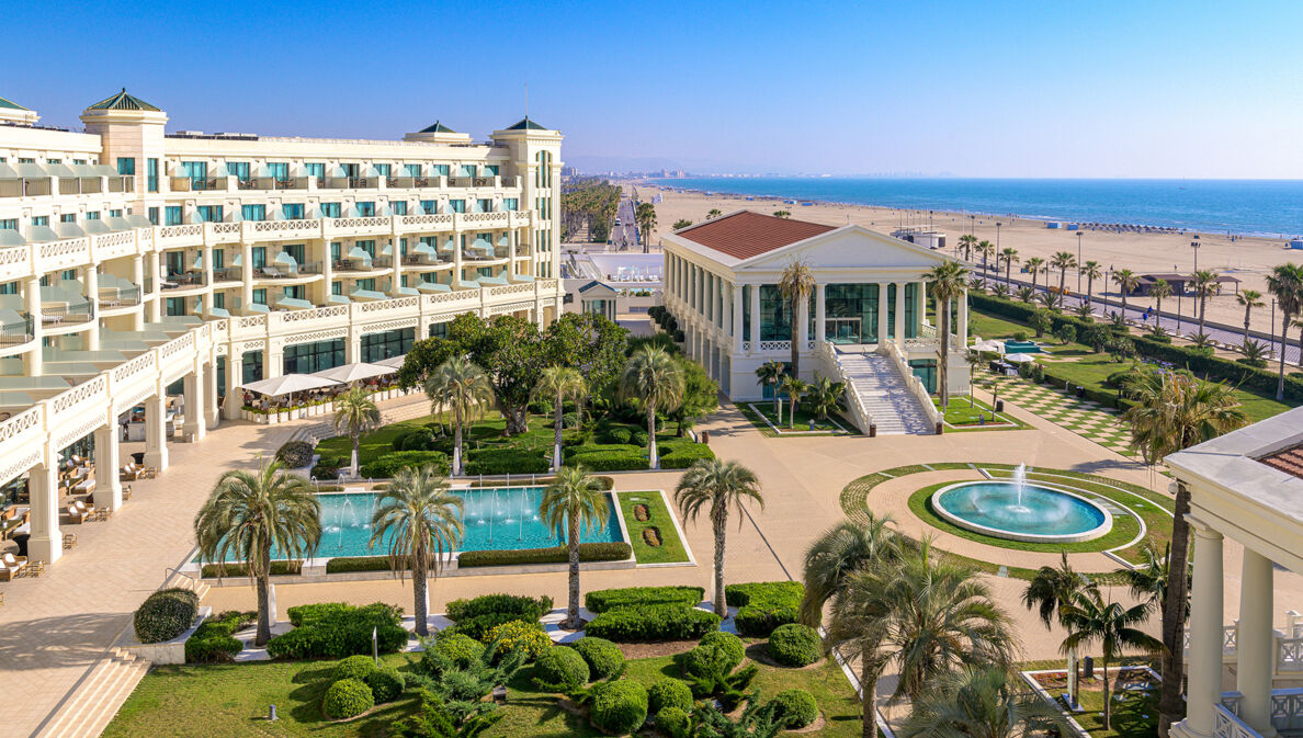 Luxuriöse Hotelanlage mit Pools und Palmengarten an einem breiten Sandstrand.