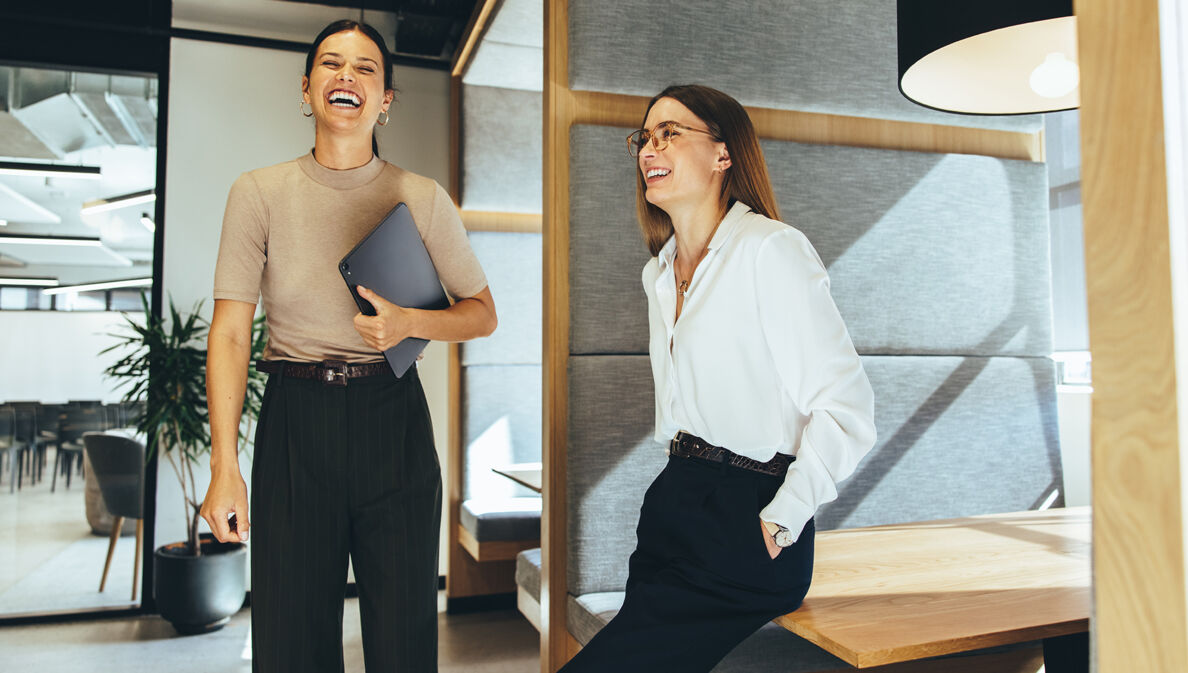 Zwei junge Geschäftsfrauen lachen im Büro