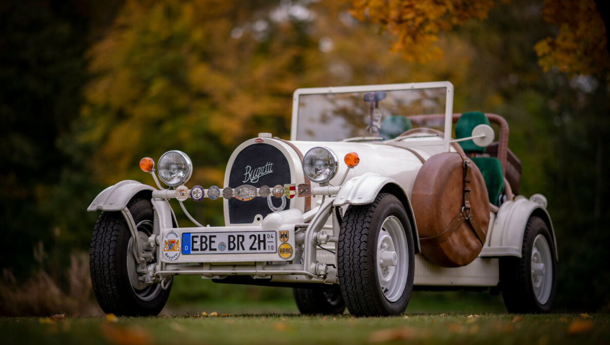 Weißer Bugatti Cabriolet Oldtimer mit H-Kennzeichen in einem Park.