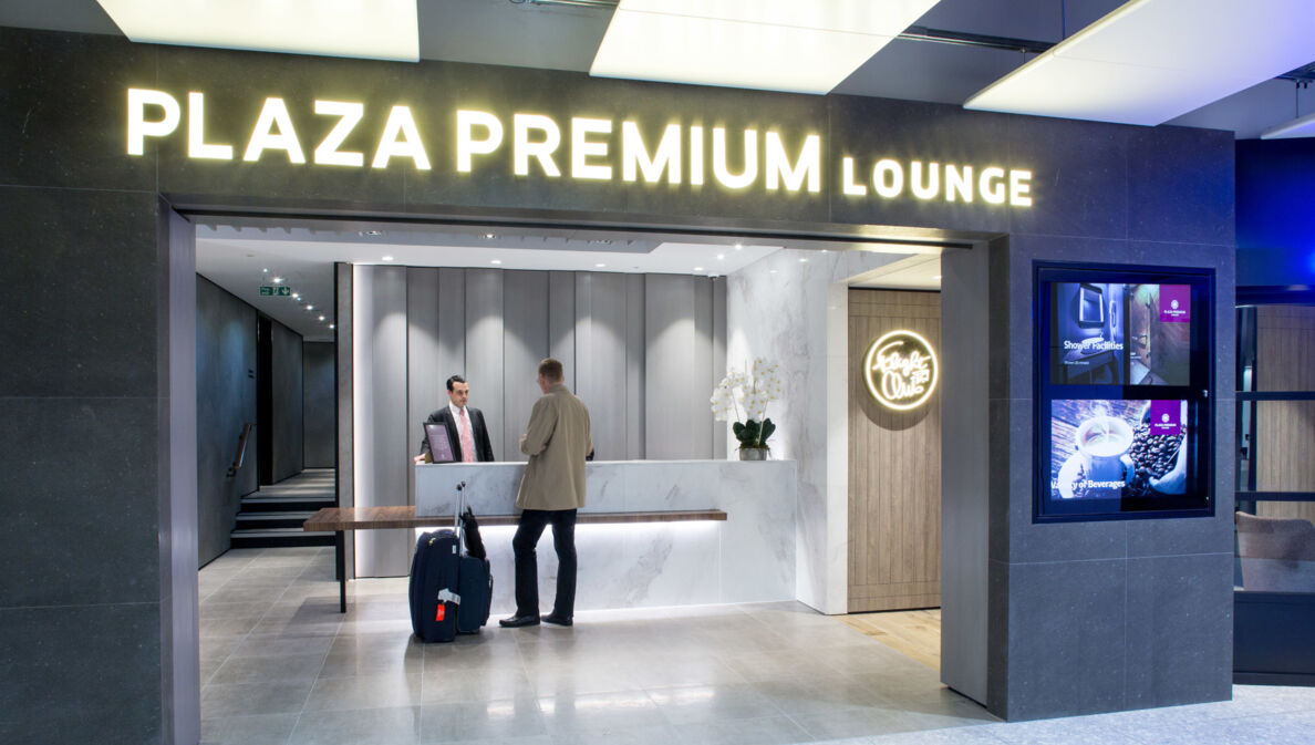 Ein Mann mit Gepäck beim Check-in am Eingang einer Plaza Premium Flughafen-Lounge.