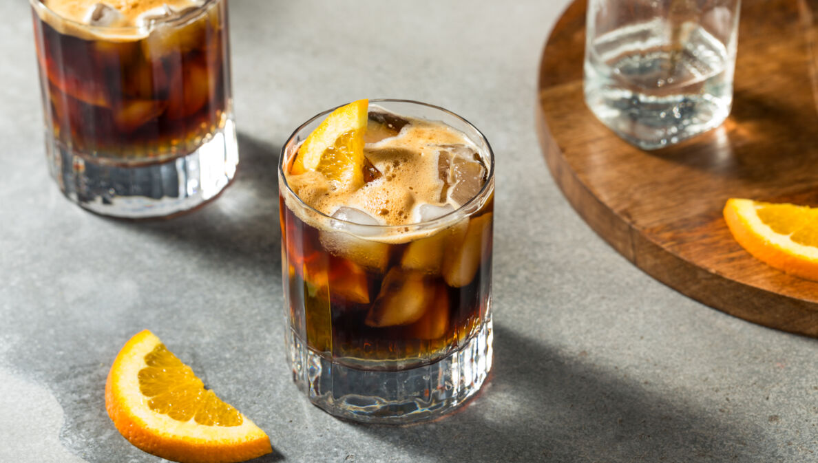 Zwei Gläser Espresso Tonic mit Eiswürfeln und Orangenscheiben.