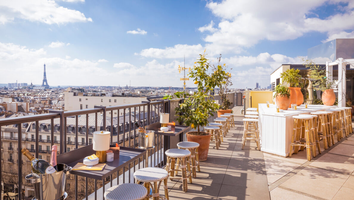 Dachterrasse des Restaurants Perruche mit Blick auf die Dächer von Paris und den Eiffelturm in der Ferne.