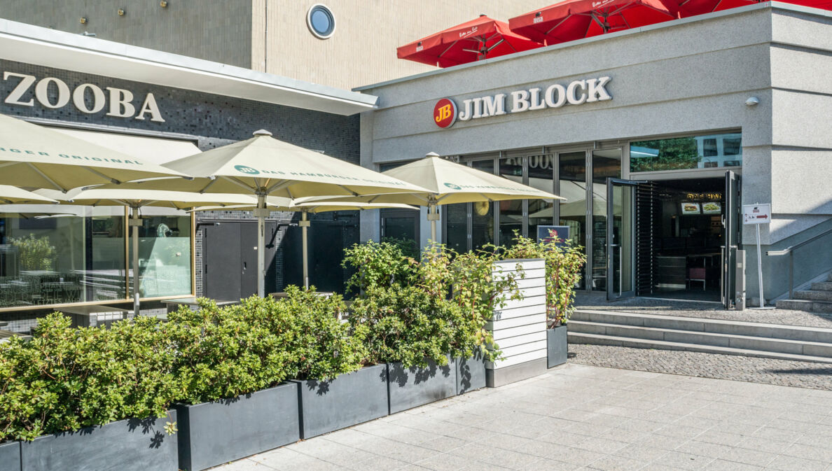 Eingang zu einem Jim Block Restaurant in einem grauen Gebäude.