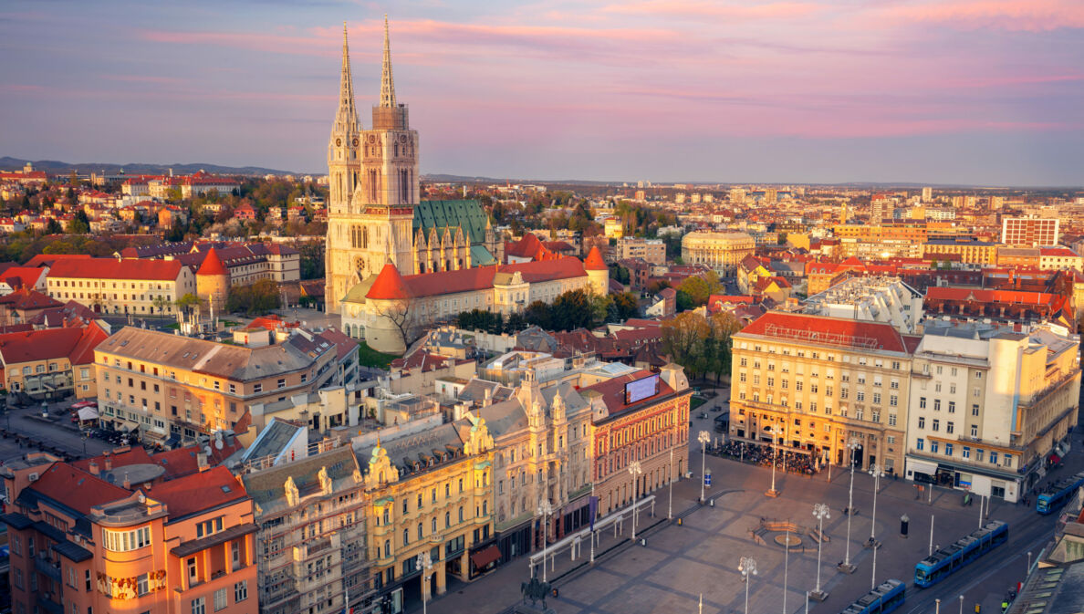 Stadtpanorama von Zagreb mit Kathedrale bei Abenddämmerung.