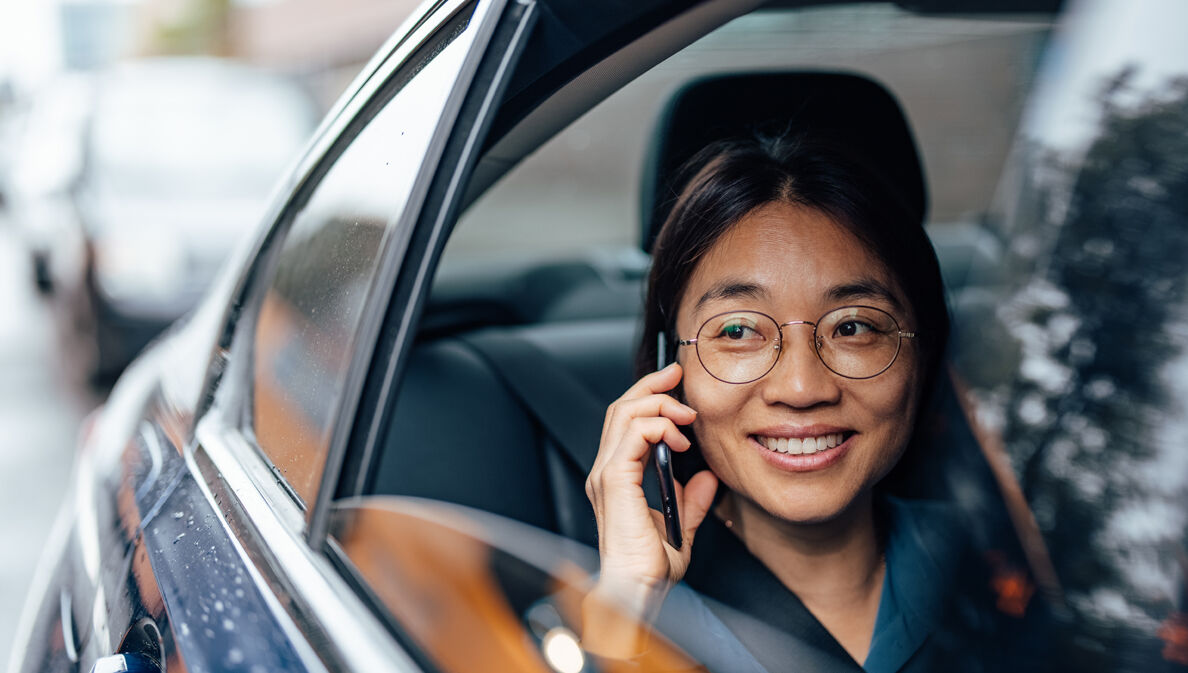 Eine Geschäftsfrau nutzt den SIXT ride Chauffeur-Service.