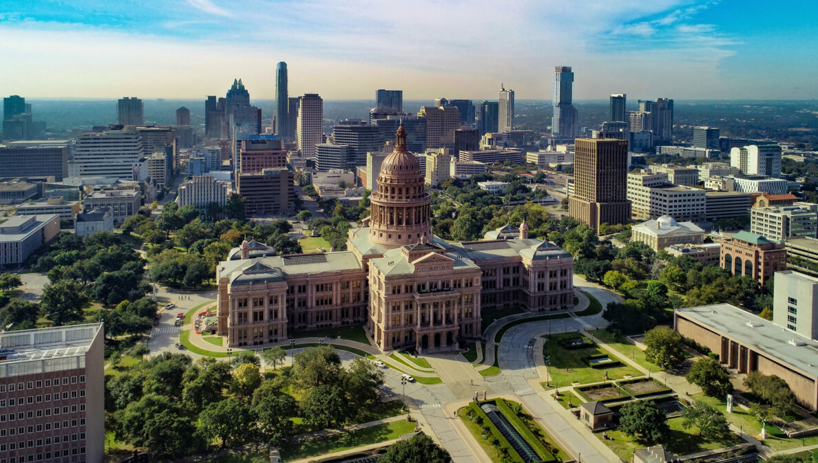 Texas State Kapitolgeböude vor der Skyline von Austin aus der Luftperspektive.