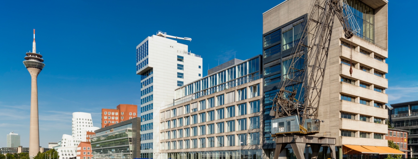 Verschiedene Gebäude mit Kran am Düsseldorfer Binnenhafen, Hintergrund ein Fernsehturm.