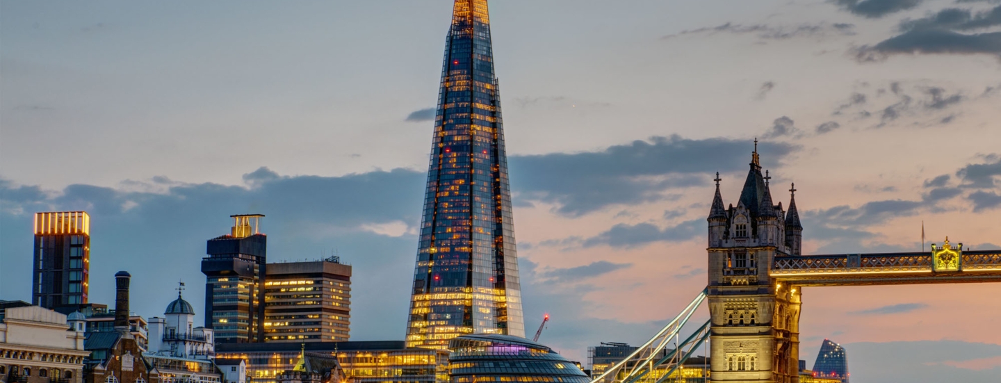 Beleuchtete Londoner Skyline mit Wolkenkratzer The Shard und Tower Bridge am Abend.